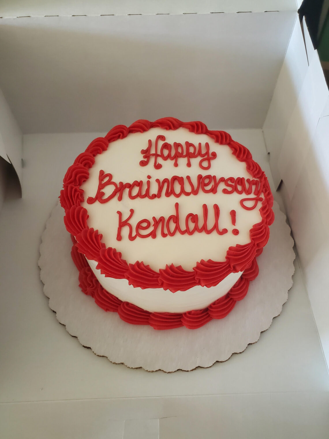 a circular cake with the words ' happy brainaversary kendall!'