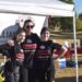 a woman and 2 teens standing in front of a large banner outside in black shirts and leggins. the shirts match and read "Angioma Alliance"